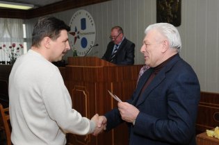 Генеральный директор Е.С. Баранкин вручает удостоверение «Ветеран труда завода» мастеру участка В.В. Юкину